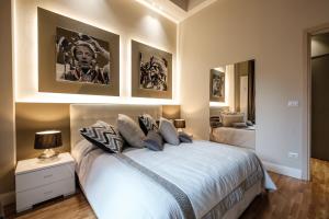a bedroom with a white bed with a night stand and a mirror at Apart Hotel Torino in Turin