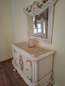 a white dresser with a mirror on top of it at Zum Böhmen Ferienwohnung Fridericke in Bad Langensalza