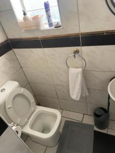 a small bathroom with a toilet and a sink at Executive B & B in Beacon Bay