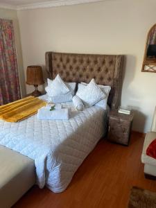 a bedroom with a large bed with white sheets and pillows at Executive B & B in Beacon Bay