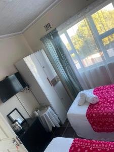 a small room with two beds and a window at Executive B & B in Beacon Bay +7 photos