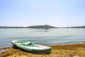 a kayak sitting on the shore of a body of water at Large lakeside villa in Lesa