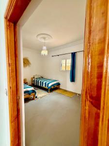 a room with two beds and a room with a door at Dar Rime in Ghazoua