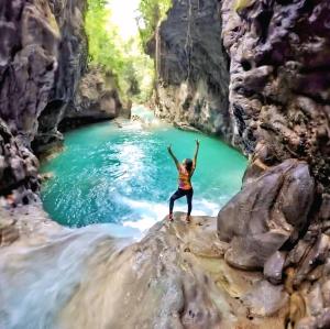 a woman standing on a rock in front of a river at Beach Pool Hotel Punta Cana in Punta Cana