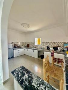 a kitchen with white cabinets and a counter top at Dar Rime in Ghazoua