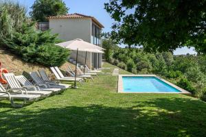 a group of chairs and an umbrella next to a swimming pool at aMaRe Country House in Caminha