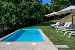 a swimming pool with lounge chairs and umbrellas at aMaRe Country House in Caminha +46 photos
