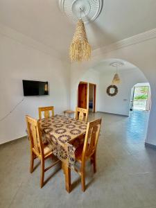 a dining room with a table and chairs and a chandelier at Dar Rime in Ghazoua