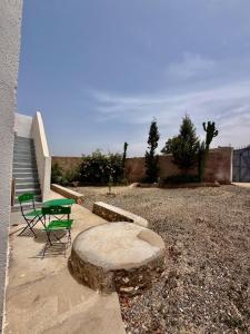 a picnic table and chairs on a patio with stairs at Dar Rime in Ghazoua