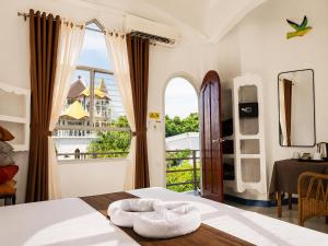 a bedroom with a bed and a large window at MG Chateau Resort in El Nido