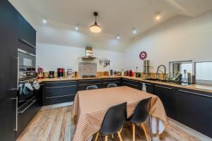 a kitchen with a table and chairs in a kitchen at Villa Léonie - piscine intérieure in Kerlouan
