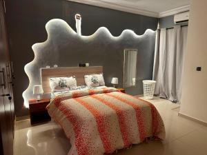 a bedroom with a large bed with a large headboard at Immobilier du siecle in Abidjan
