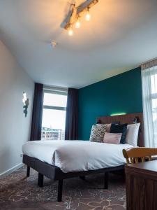 1 dormitorio con cama y pared verde en Linden Hotel, en Ámsterdam