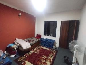 a small room with a bed and a fan at Gupta House in Katmandu International