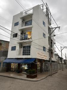 a tall white building with a sign on it at Edificio Villa Linda Urb El Parque in Barranquilla