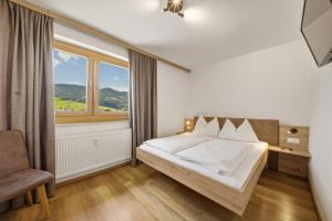 a bedroom with a bed and a large window at Kaprun Apartments in Kaprun