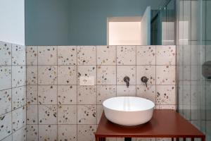a bathroom with a white sink on a wooden table at Design Apartment in Monopoli +20 photos