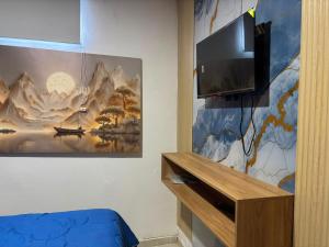 a room with a tv and a painting on the wall at Edificio Villa Linda Urb El Parque in Barranquilla