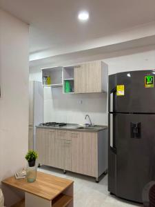 a kitchen with a stainless steel refrigerator and a table at Edificio Villa Linda Urb El Parque in Barranquilla
