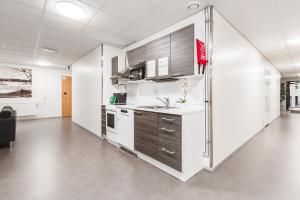 a kitchen with white cabinets and a sink in a room at LODGE Aparthotel Raahe in Raahe