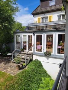 a house with a patio with tables and chairs at Kurparkhotel-Gemünd in Gemünd