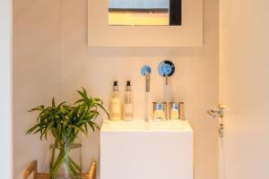 a bathroom with a white counter with bottles on it at Moledo Front Beach by Portugal Active in Viana do Castelo
