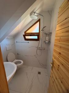 a bathroom with a toilet and a sink and a window at Naimi in Pukë