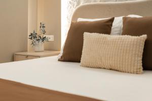 a bed with brown pillows and a white pillow at Armal Studio in Mostar