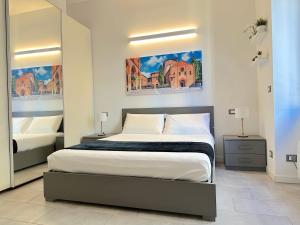 a bedroom with a large bed and a mirror at Demetra Apartment in Bologna