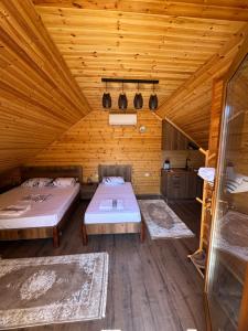 a room with two beds in a wooden cabin at Naimi in Pukë