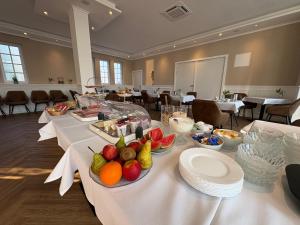 a long table with fruits and plates on it at Weingut Lindenhof in Thörnich