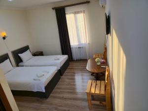 a room with two beds and a table and a television at NUR TOON in Areni
