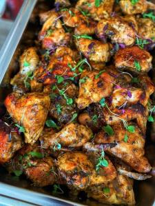 a tray of food with chicken with sauce and herbs at BelizeprivateChef in Dangriga