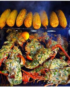 a tray of food with corn and crabs and other foods at BelizeprivateChef in Dangriga