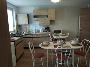 a kitchen with two tables and chairs with pots on them at Tulipán Apartmanház in Bük +23 photos