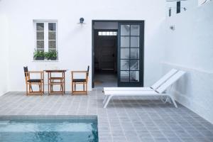 un patio con mesa y sillas junto a una piscina en Cas Conco, en Es Mercadal