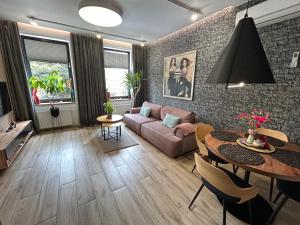 a living room with a couch and a table at Apartamenty Częstochowa pod Jasną Górą Teresy 4-2 parking gratis in Częstochowa