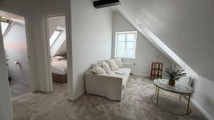 a white living room with a couch and a bed at Lotmiškio 1 in Neringa