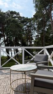 a patio with a table and chairs and trees at Lotmiškio 1 in Neringa