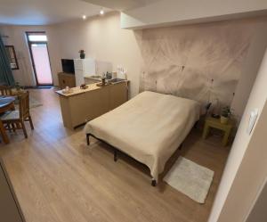 a bedroom with a large bed and a kitchen at Bracka Dom in Pabianice