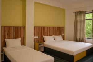a room with two beds and a window at Sarai Stay in Kargil