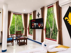 a room with a bed and a tv and windows at MG Chateau Resort in El Nido +35 photos