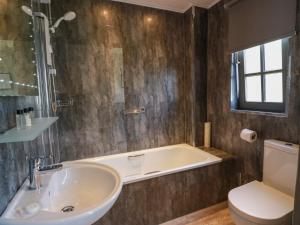 a bathroom with a tub and a sink and a toilet at 7 Brunston Avenue in Girvan +26 photos