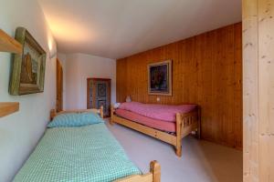 two beds in a room with wooden walls at Charmante Wohnung im Dorfkern in Klosters