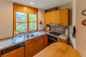 a kitchen with wooden cabinets and a sink and a window at Charmante Wohnung im Dorfkern in Klosters