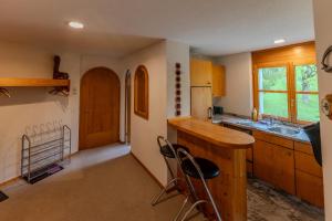 a kitchen with a sink and a counter with chairs at Charmante Wohnung im Dorfkern in Klosters +8 photos