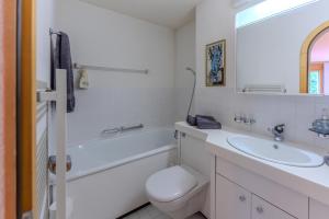 a white bathroom with a sink and a toilet at Charmante Wohnung im Dorfkern in Klosters