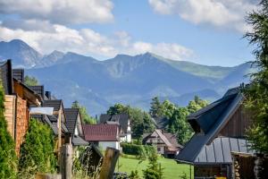 a village with mountains in the background at Domek u Hanci Pod Gubałówką z Jacuzzi in Ząb