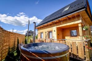 a large hot tub in front of a wooden house at Domek u Hanci Pod Gubałówką z Jacuzzi in Ząb