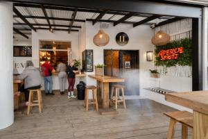 eine Gruppe von Menschen steht in einem Restaurant mit Tischen in der Unterkunft Eleven in Plettenberg Bay